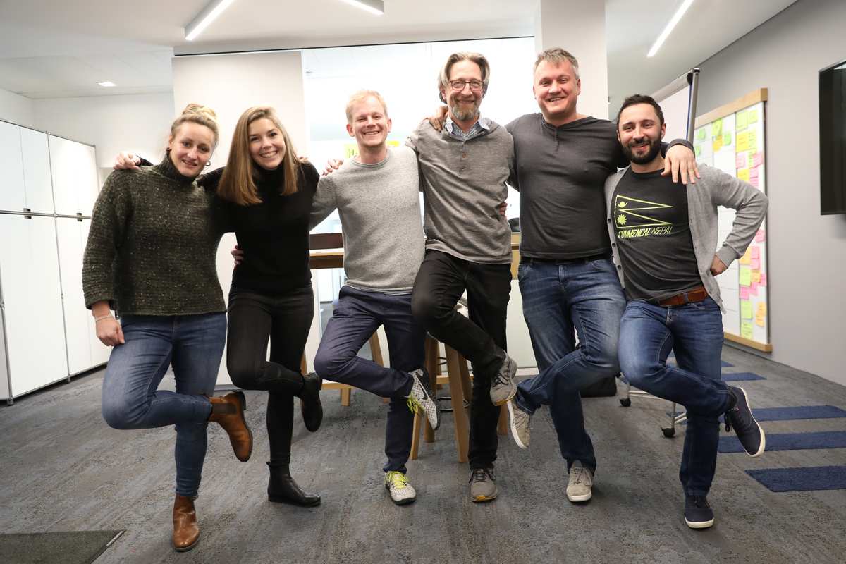 ein Team von 6 Leuten posiert als Linedancer im Büro