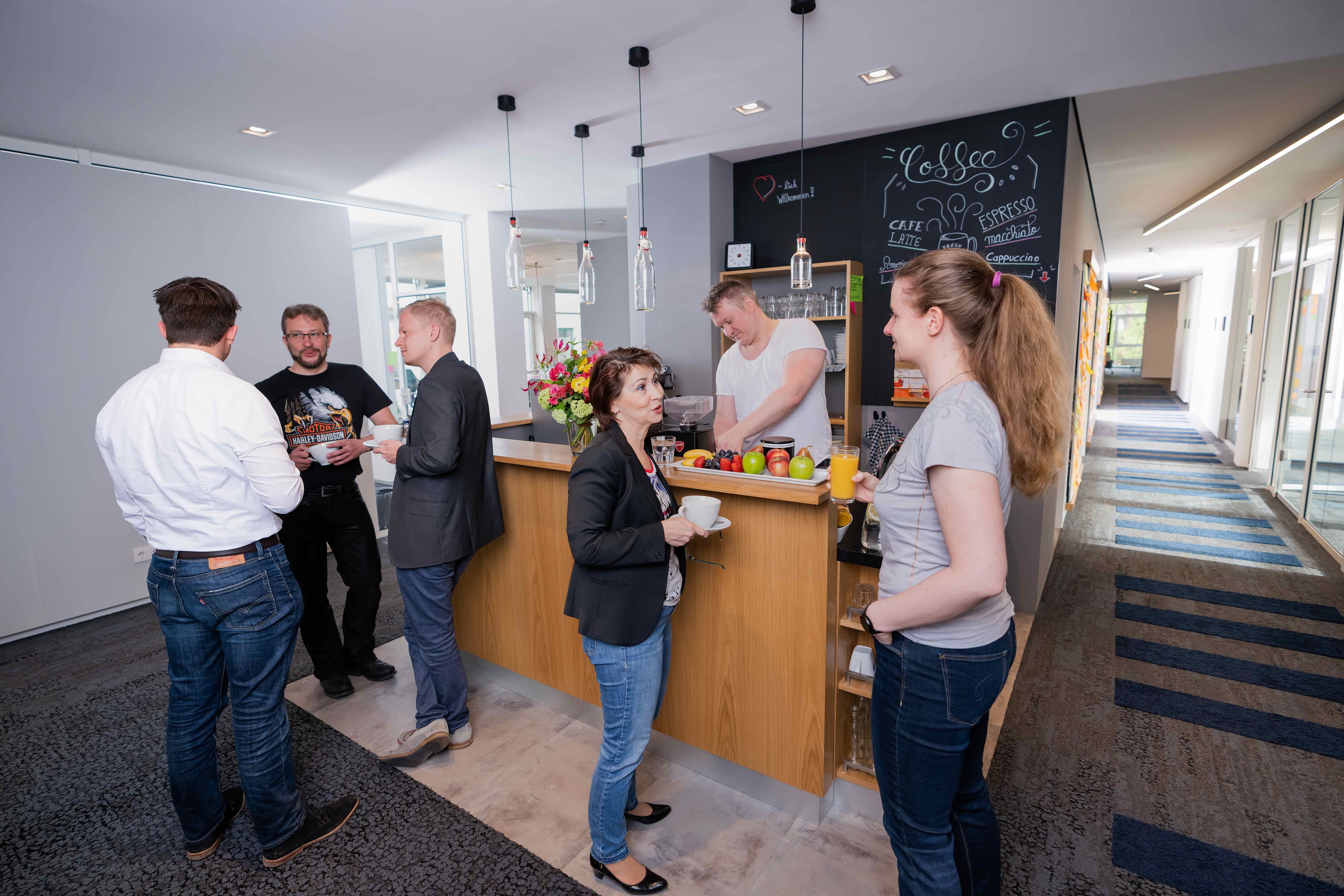 Menschen stehen um eine Kaffeebar herum und unterhalten sich