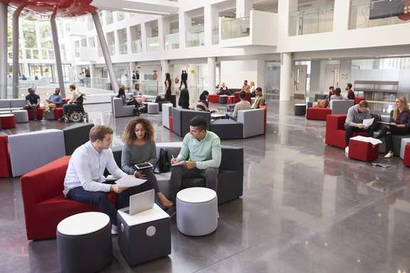 People working in groups together in a large space.