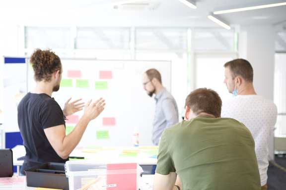 Ein agiles Team bei der Arbeit vor einem Kanban Board