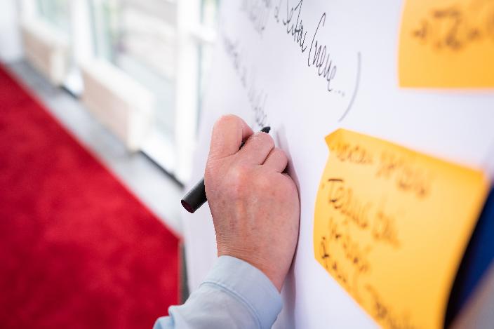 Eine schreibende Hand mit einem Flipchart