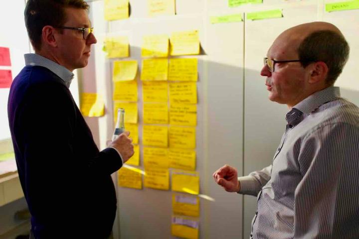 Schulungsteilnehmer diskutieren am Kanbanboard
