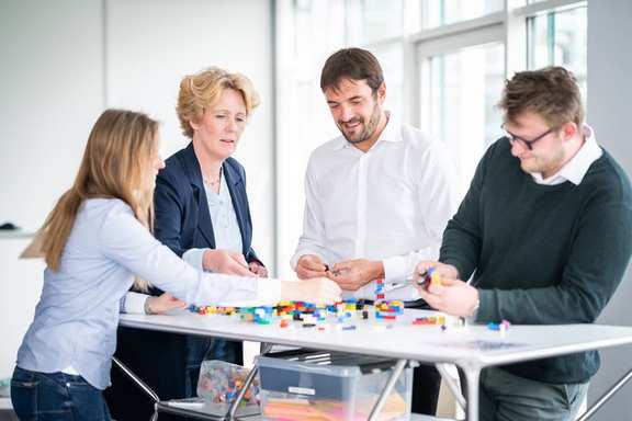 Das Bild zeigt einTeam, das zusammen etwas erarebeitet.