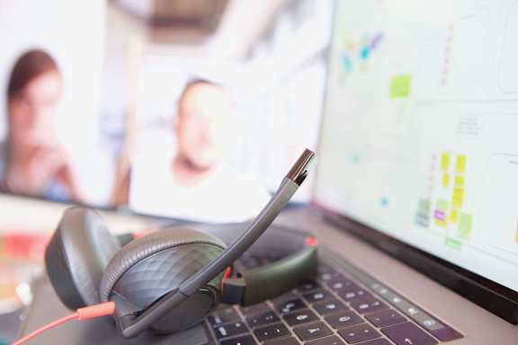 Ein Headset, das auf einem Notebook liegt.