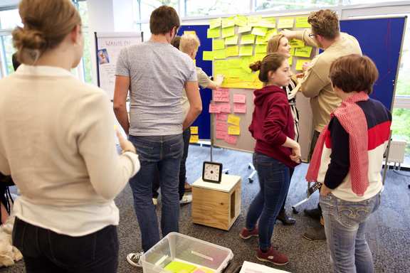 An amused team in front of a planning wall