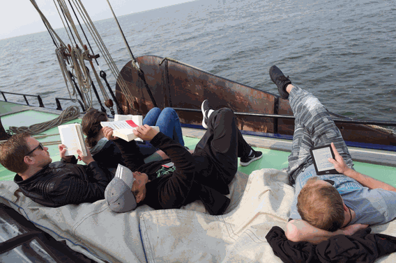 Leute chillen und genießen das Segeln auf dem Schiffsdeck