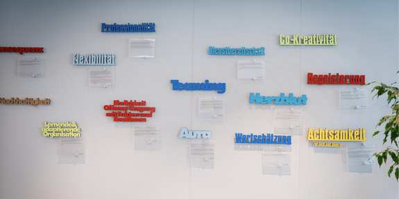 eine Wand mit bunten 3D-Wörtern zu Werten und deren Geschichten