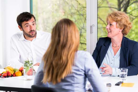 ein Mann und eine Frau im Bewerbungsgespräch mit einer Bewerberin