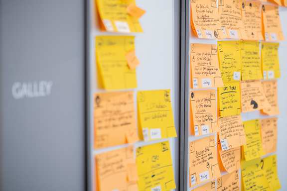 a section of a planning wall with different colored postits