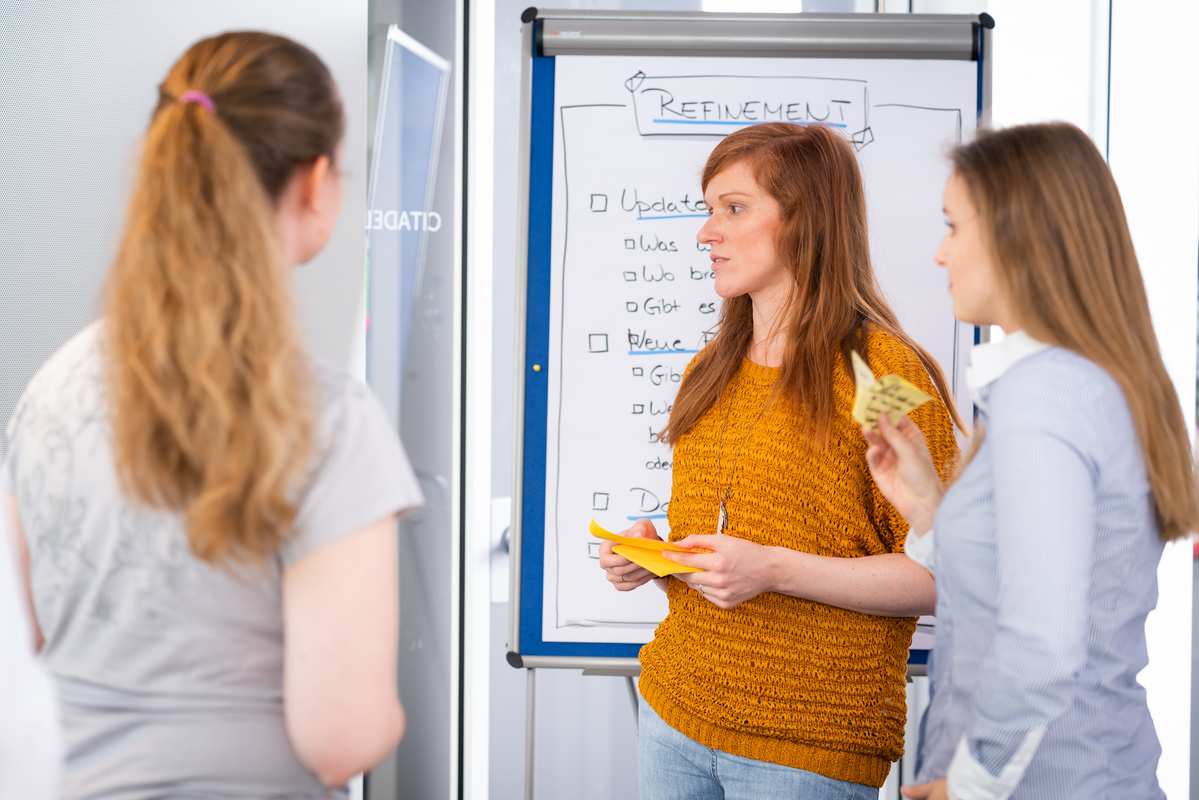 3 people plan refinement on planning wall