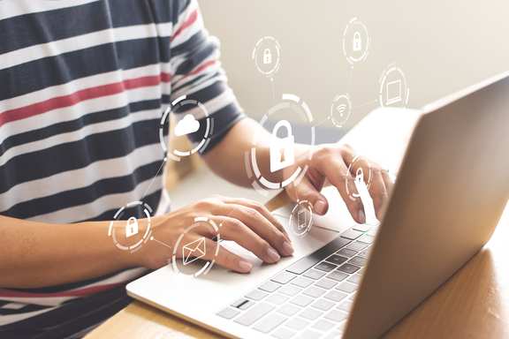 Lock symbols appear over hands of man working on laptop