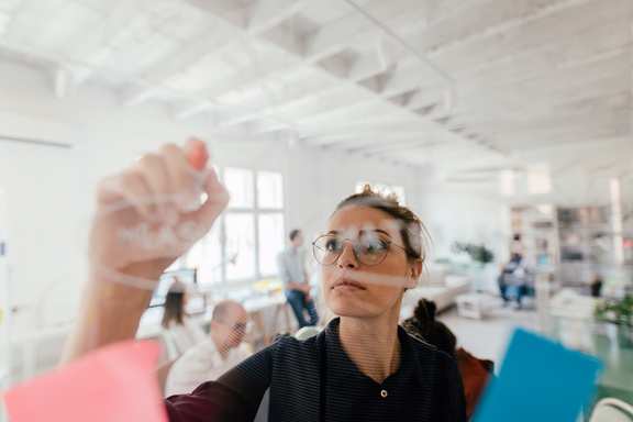 Frau, die an einem Glas-Board arbeitet