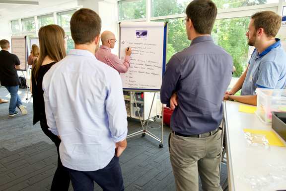 Team works on a flipchart in a large room on the topic of Agile principles