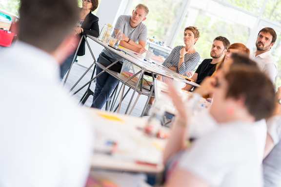 A training room at wibas with a crowd of people at bar tables