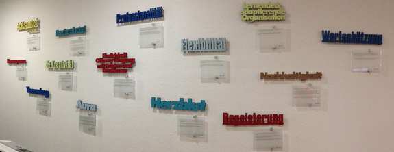 on one wall are lasered wooden words of values with little stories that symbolize them